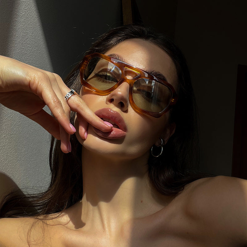 model wearing the river sunglasses from vehla eyewear in honey tort / sage